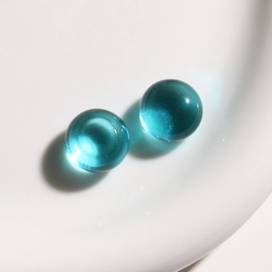 Macro de dos cuentas de resina verde azulado transparentes con acabado de vidrio