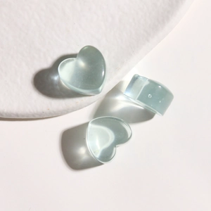 Macro shot of translucent light blue resin heart pendants and a matching chunky ring