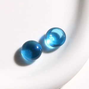 Foto macro de dos cuentas redondas de resina azul translúcida con acabado de vidrio