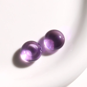 Detalle macro de cabujones redondos de resina violeta translúcida para crear joyería