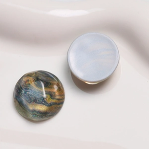 Macro detail of retro round resin cabochons with colorful oil painting water ripple pattern