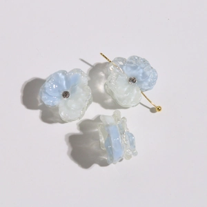 Detailed macro view of clear blue gradient petal resin earrings with rhinestone accents