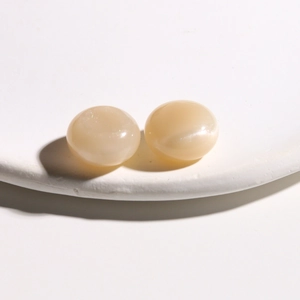 Macro detail of 15mm cream resin glitter round cabochons for DIY jewelry making