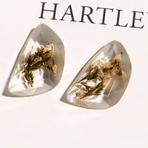 Detailed close-up of faceted clear resin charms with embedded real dried flowers