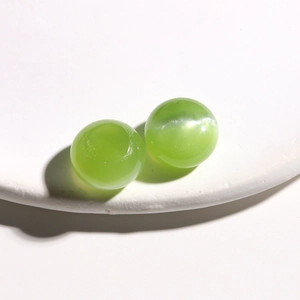 Macro shot of 15mm light green cat-eye resin beads with smooth finish for DIY crafts