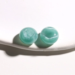 Macro detail of 15mm round resin beads with blue shimmer and cat-eye effect for DIY jewelry