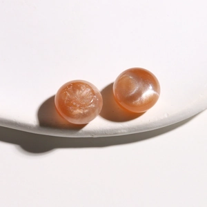 Macro shot of 15mm orange round cabochon stones with shimmering sunstone luster