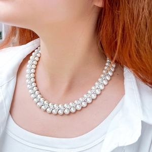 Detail of elegant double-layer freshwater pearl necklace with zircon floral spacers on neck