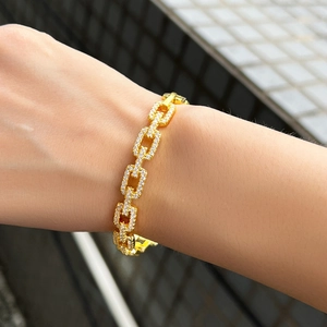 Detail van een luxe goudkleurige schakelarmband met fonkelende zirkonia micro-zetting