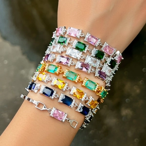 Dettaglio macro di bracciali a strati con zirconi rettangolari e alone scintillante