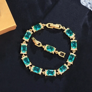 Elegante bracciale in oro con pietre verde smeraldo e pavé di zirconi bianchi su velluto scuro