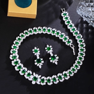 Parure bijoux émeraude avec collier et boucles d'oreilles sur un fond sombre chic