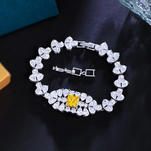 Detalle de una pulsera de lujo plateada con piedras amarillas cuadradas y cierre incluido