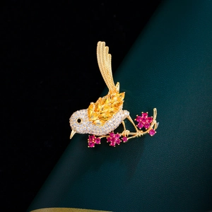 Exquisite magpie bird brooch with yellow zircon wings perched on a floral branch