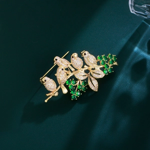 Exquisite gold-tone bird brooch with sparkling cubic zirconia and green gemstones