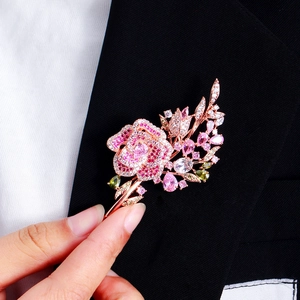 Roségoldene Brosche mit rosa Zirkonia-Rosenblüten an einem eleganten Anzugrevers