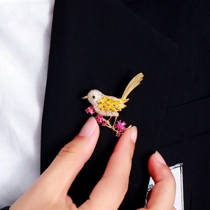Exquisite magpie bird brooch with yellow zircon and floral gemstones on black blazer