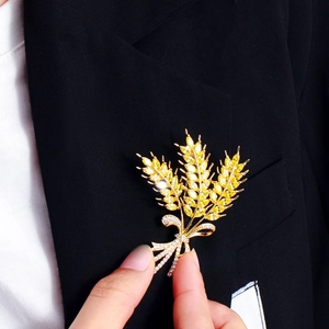 Luxurious gold wheat ear brooch with yellow zircons pinned on a black blazer lapel