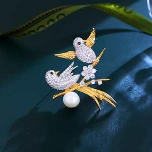 Elegant gold-plated double bird brooch with sparkling crystals and a lustrous pearl