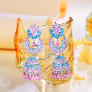Detail of luxury long dangling earrings with pink and blue zircons on glass rim