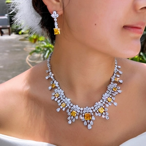 Luxe sieradenset met gele edelstenen en witte zirkonia, gedragen door een model