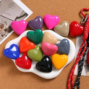 Macro shot of colorful polished heart charms in a dish for DIY jewelry making