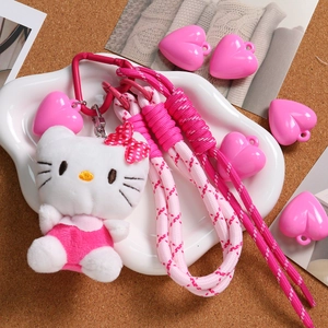 Rosa Herzanhänger und Hello Kitty Plüsch-Schlüsselanhänger auf einem weißen Tablett
