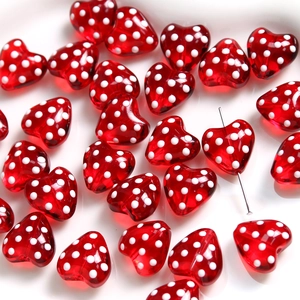 Close-up of red heart glass beads with white polka dots for DIY jewelry making