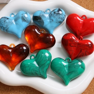 Makroansicht von Herzanhängern aus Marmorharz in Blau und Bernstein für DIY-Schmuck