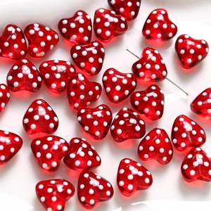 Close-up of red heart glass beads with white polka dots for jewelry making