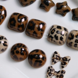 Macro-opname van diverse harsbedeltjes met luipaardprint, harten en strikjes