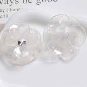 Detailed close-up of transparent resin flower hair accessories with lace texture and crystal
