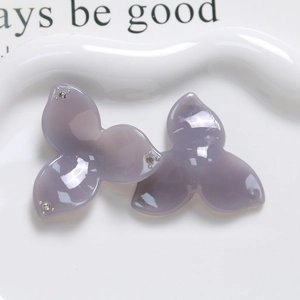 Dettaglio di ciondoli floreali in resina viola con strass per creazione di gioielli