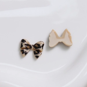 Detailweergave van luipaardprint hars strikbedeltjes voor DIY-accessoires, voor en achter