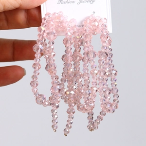 Détail macro de perles en cristal rose clair avec facettes sur carte à bijoux