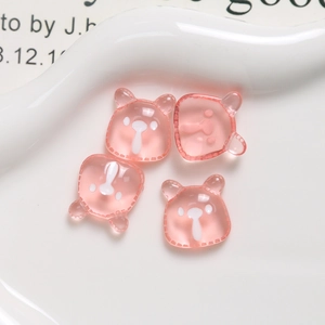 Close-up of four translucent pink resin cartoon bear charms for DIY jewelry making