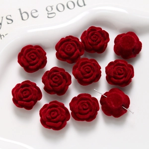 Close-up of red flocked velvet rose beads with holes for DIY jewelry making and crafts