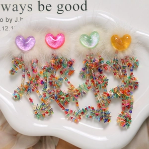 Detail of colorful heart charms with mink fur trim, sequins, and beaded tassels