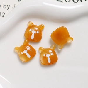 Macro shot of amber orange bear-shaped resin flatback charms for DIY crafts and accessories