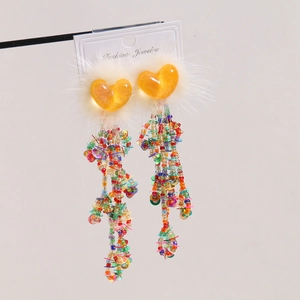 Detail of colorful tassel earrings with orange sequin hearts and white plush fur trim