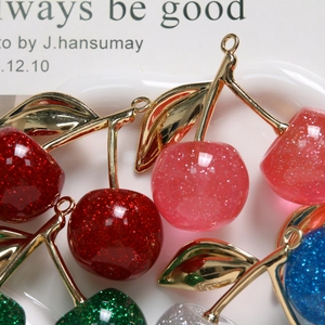 Detail von Glitzer-Kirsch-Anhängern in verschiedenen Farben für DIY-Schmuck