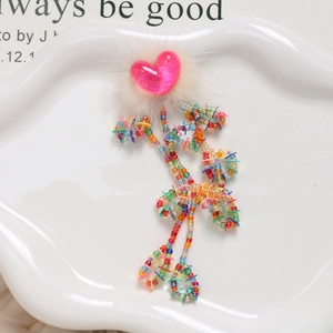 Close-up of colorful tassel beads with sequins and heart faux fur for DIY crafts