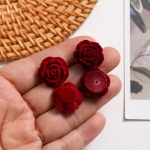 Handheld view of dark red flocked velvet rose charms for DIY jewelry and accessories