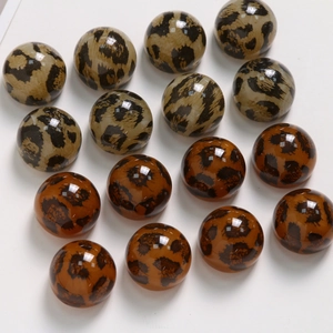 Detailansicht polierter Acryl-Cabochons mit Leopardenmuster in Grau- und Bernsteintönen