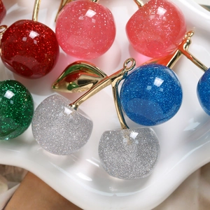 Glitzernde Kirsch-Anhänger mit goldenen Stielen und Ringen in verschiedenen bunten Farben