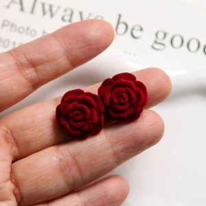 Macro view of velvet-flocked burgundy rose studs showing realistic petal textures