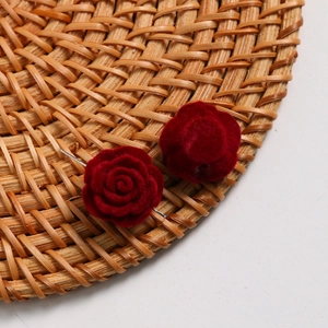 Detailed view of burgundy velvet rose earring studs showing soft flocked texture and petals