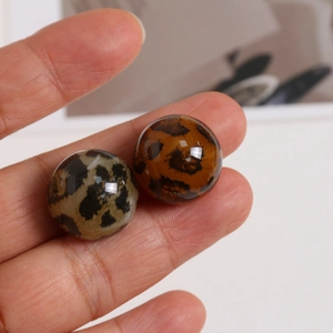 Nahaufnahme von runden Acryl-Anhängern mit Leopardenmuster für DIY-Ohrringe