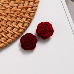 Close-up of deep red velvet rose charms with textured flocking for DIY jewelry making