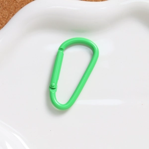 Detail of green D-shape aluminum alloy carabiner with smooth painted finish for keychains